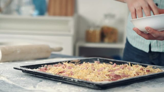 Chef hand sprinkle pizza with cheese