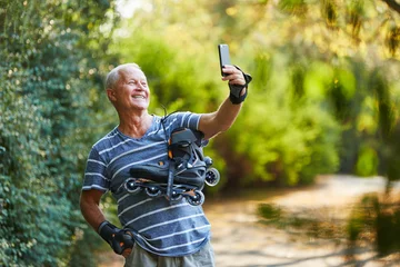 Tuinposter Vitaler Senior macht ein Selfie © Robert Kneschke