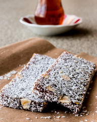 Turkish Dessert Cezerye with walnut, coconut powder and tea