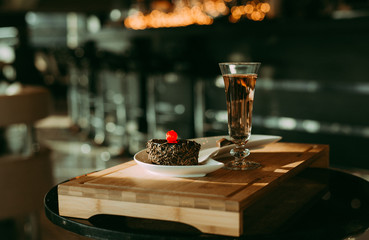 Mouth watering cream chocolate chip cake, cherry on top  & glass of champagne