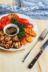 grilled vegetables with sauce on a wooden background