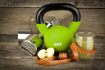 The concept of weight loss, dumbells and kettlebell, diet and fitnes
