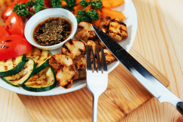grilled vegetables with sauce on a wooden background