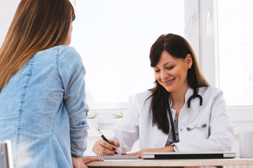 Obraz premium Female doctor writing prescription to patient