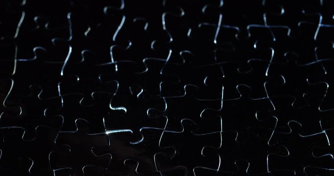 A creative completes the black or white light puzzle putting the last missing piece. Concept: cooperation, teamwork, creativity, and access solution.