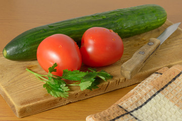 Tomatoes and cucumbers on the cutting board.