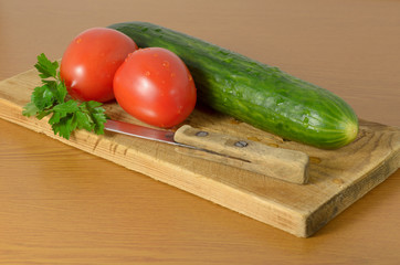 Tomatoes and cucumbers on the cutting board.
