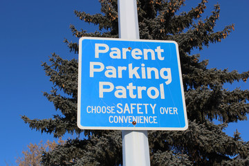 Parent Parking Patrol Sign Against Tree and Blue Sky