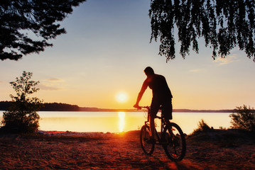 Fototapeta na wymiar boy on a bicycle at sunset. Carpathian, Ukraine, Europe