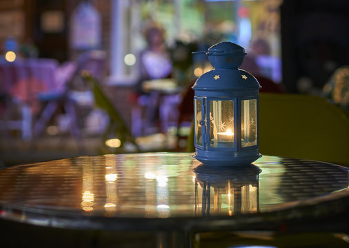 Metal Table Top Lantern At Night Outside A Cafe