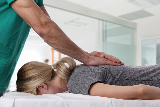 Woman having chiropractic back adjustment. Osteopathy, Alternative medicine, pain relief concept. Physiotherapy, sport injury rehabilitation
