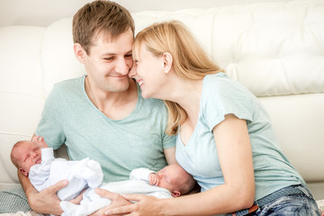 young loving family of 4 with newborn twin babies, indoor portrait