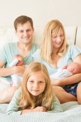 Obraz premium big family of 5 with older daughter and baby twins, indoor portrait at home
