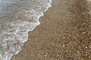 Oncoming waves on a beach sand. Backgrounds and textures
