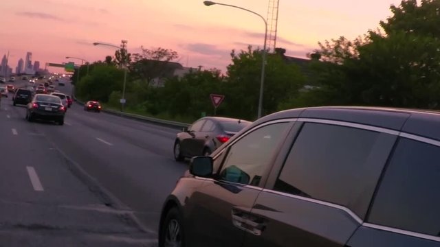 Driving on the highway towards the Philadelphia skyline as the sun sets. Slow Motion 240fps