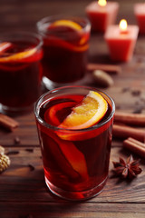 Glass of delicious Christmas mulled wine on wooden background, closeup