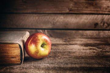  book and apple on the wooden table