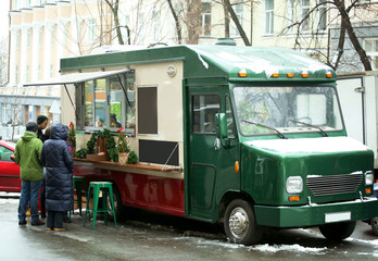 Fototapeta na wymiar Food truck with people at Christmas fair