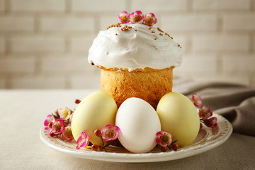 Plate with sweet Easter cake and eggs on table