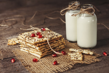 Dietary crunchy cracker with cereals and milk on a dark wooden background.