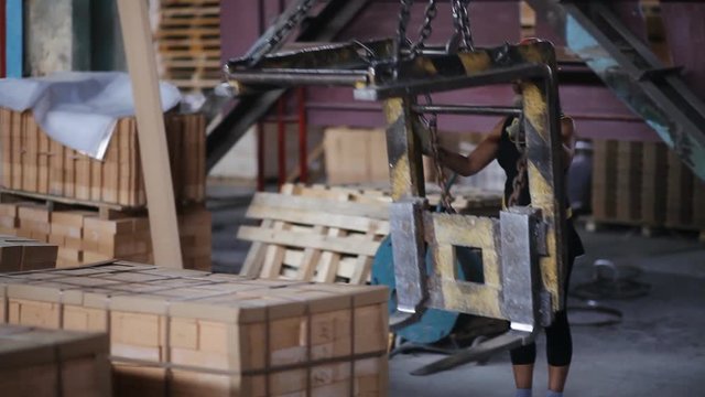woman Factory worker in helmet transporting packing firebricks with workshop rail mounted gantry crane