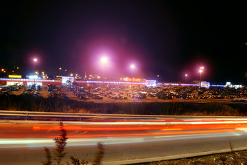 Parcheggio centro commerciale di sera con scie di luci