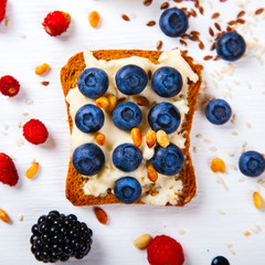  Sandwiches sweet with cream-cheese and fresh blueberry over pine Nut,and honey,a white background . Concept of Healthy Food.Breakfast snack.selective focus.