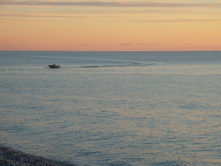 Small boat in the sea, sunset sky