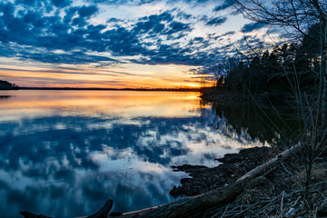 Clouds and colorful sunset reflected in a glass like lake