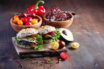 Vegan wholegrain sandwich with ingredients for healthy meal,  avocado, micro greens, super food, diet concept, selective focus, toned image