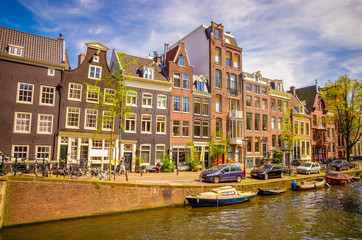 Obraz premium Traditional old buildings and boats in Amsterdam, Netherlands. Canals of Amsterdam.
