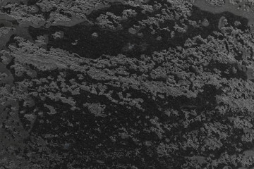 Black slate table top being cleaned showing wet streaks.