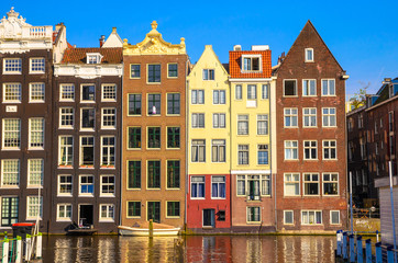 Fototapeta na wymiar Traditional old buildings and boats in Amsterdam, Netherlands. Canals of Amsterdam.