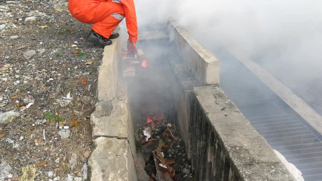 Worker fogging drain with insecticides to kill aedes mosquito breeding ground, carrier of dengue virus