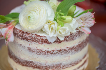 Obraz na płótnie Canvas Flowers decorated red sponge cake with vanilla cream