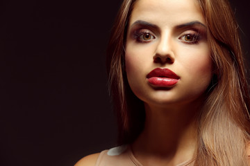 Fototapeta premium Portrait of beautiful young woman with professional makeup on dark background