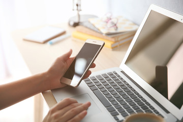 Woman with laptop and cellphone at home