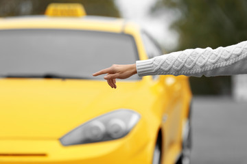 Woman catching yellow taxi cab on the street