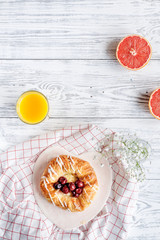 Breakfast concept with flowers on wooden background top view
