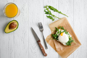 sandwich with poached eggs on wooden background top view