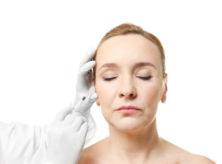 Plastic surgery concept. Mature woman receiving injection on white background