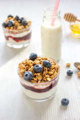Fitness breakfast with muesli, honey and milk on white table