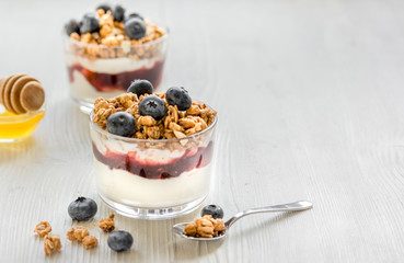 Fitness breakfast with muesli, honey and berries on white table