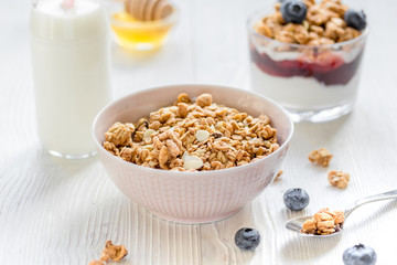 Fitness breakfast with muesli, honey and milk on white table