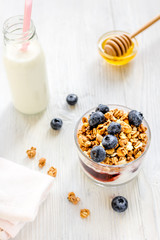 Fitness breakfast with granola, milk and honey on white background