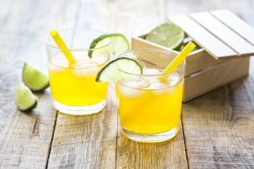 Sweet cocktails with lime and ice cubes on wooden tabel