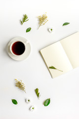 Notebook with cup of coffee on white background top view mockup