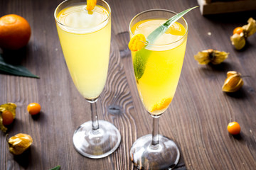 cocktail with physalis in glass on wooden background