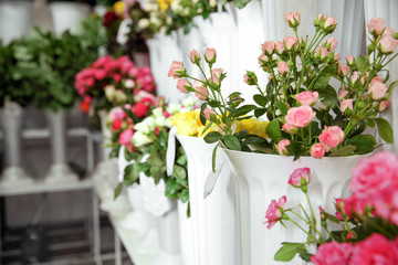 Fototapeta na wymiar Plastic vases with beautiful roses in flower shop