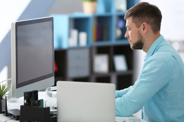 Handsome young programmer working at home